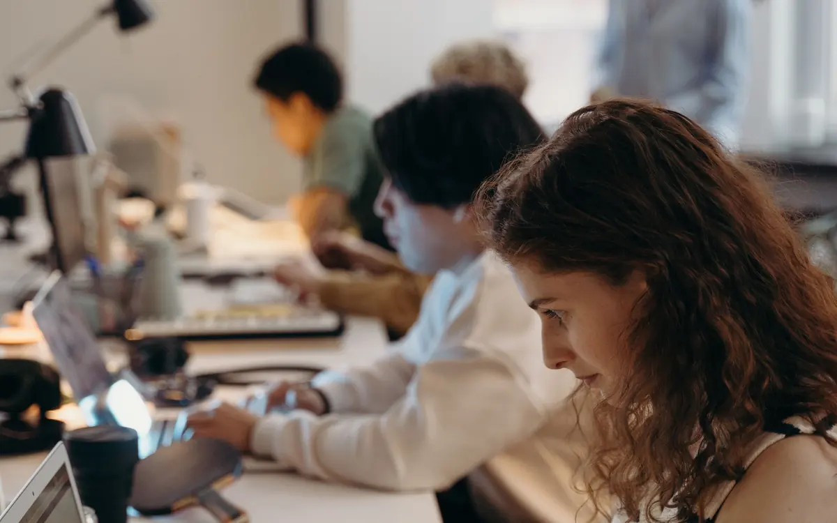 Colleagues working side by side at a shared office desk